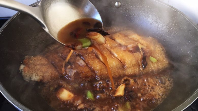 红烧鲽鱼,大火炖鱼时请用铲子铲起汤汁浇在鱼的身上,这个动作多重复几遍,以便鱼入味。