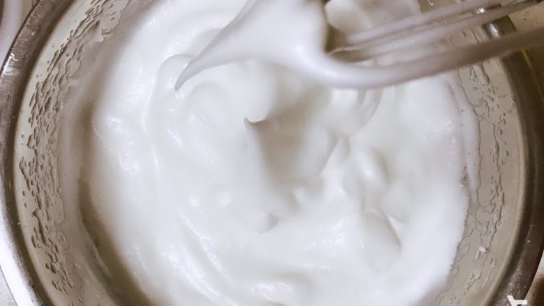 蜂蜜柚香戚风蛋糕,分三次加砂糖打发蛋白至如图弯钩状