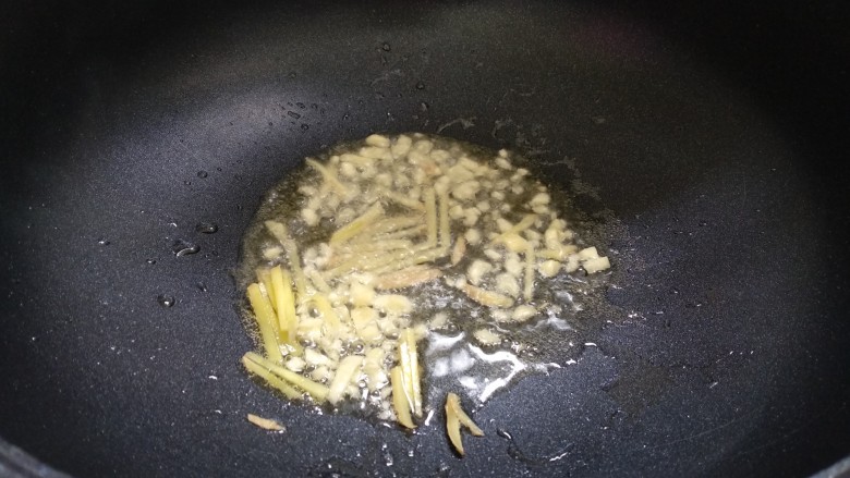 辣椒炒花蛤,锅里倒入适量金龙鱼花生油,烧七成热。放入姜蒜爆香。