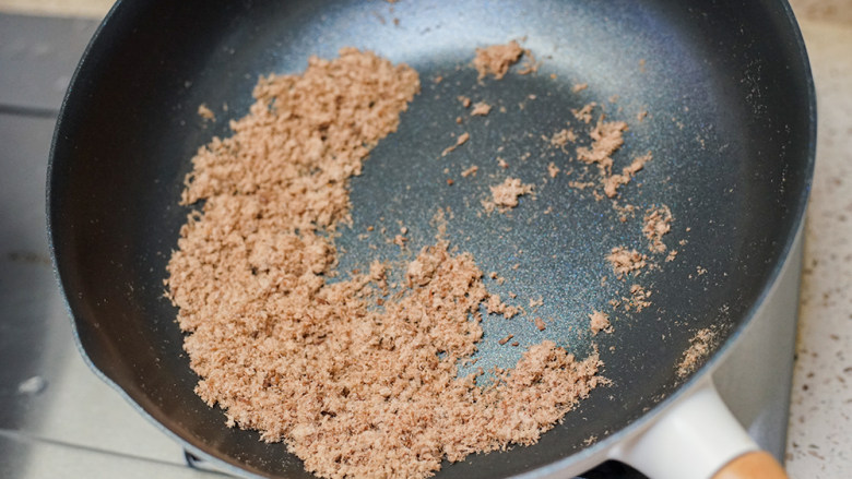 8个月以上宝宝辅食超细腻牛肉松做法,倒入九阳轻奢炒锅小火炒一下,大概半分钟,如果火大要拿锅离火5cm翻炒,这个炒锅很轻,单手拿锅没问题