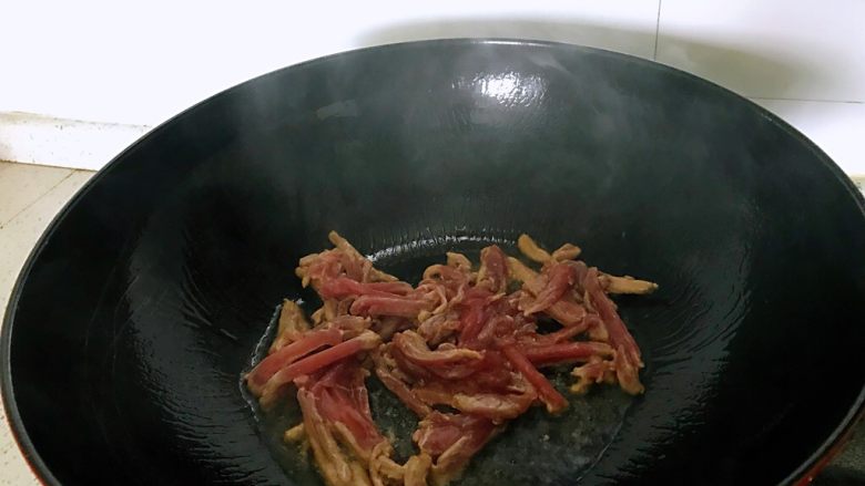 萝卜干炒肉,热锅放油、放姜、洋葱爆香,放肉爆炒、炒至肉断生。