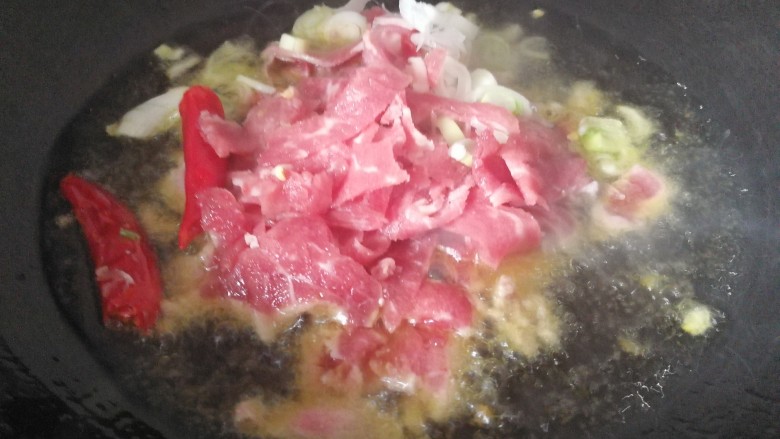 家常菜#牛肉炒芹菜粉条#,锅中添油烧热后,把牛肉,朵椒。,放入到锅内炒熟。