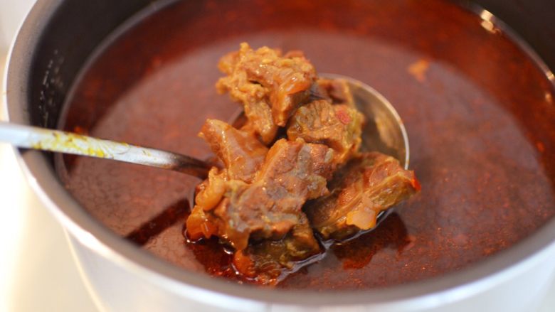 红烧牛肉面,打开锅盖,把里面的配料挑出来扔掉。