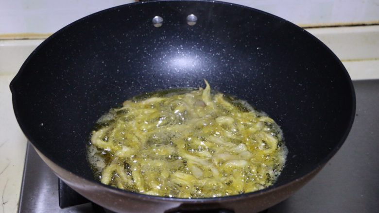 椒盐蘑菇,油温合适后多次少量加入蘑菇进行油炸