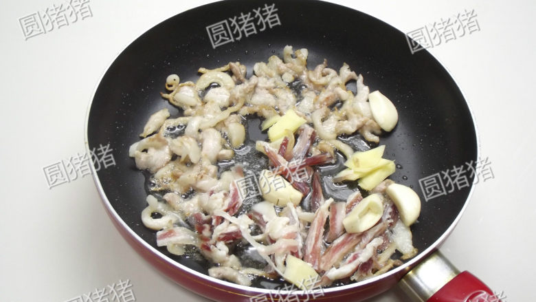 干锅茶树菇,加入腊肉条,大蒜,生姜片煸炒。