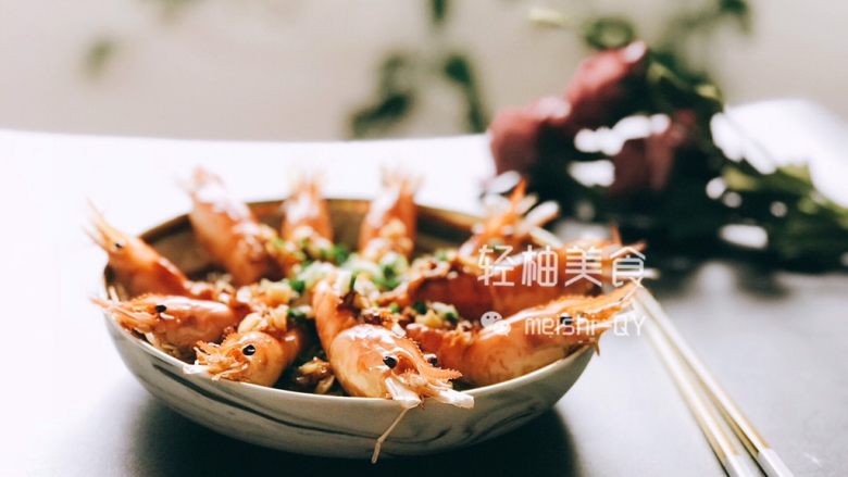 蒜蓉粉丝开背虾,蒸好后,把盘子从锅内取出,撒上切好的葱花,再淋上一汤匙的热油,即可出锅