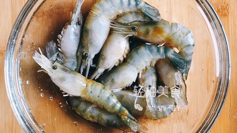 蒜蓉粉丝开背虾,用剪刀剪去虾须,并把虾的背部剪开,取出虾线,然后用菜刀在虾的背部轻拍几下,这样做的目的是敲断虾筋,使虾更加平直,避免蒸制的时候是卷曲的造型。再把处理好的虾放在小碗中,放入<a style='color:red;display:inline-block;' href='/shicai/ 788'>生抽</a>,<a style='color:red;display:inline-block;' href='/shicai/ 718'>料酒</a>,<a style='color:red;display:inline-block;' href='/shicai/ 721'>蚝油</a>,少许盐和胡椒粉腌制半小时左右
