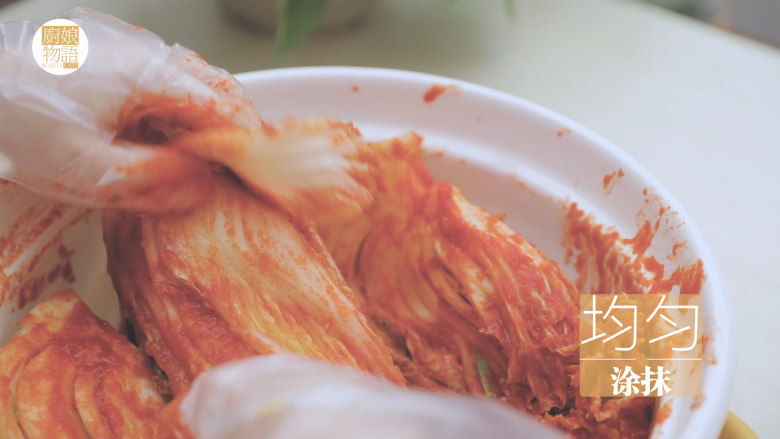 不孤独的部队火锅「厨娘物语」,将用盐腌制的白菜,洗去盐份挤干,倒入泡菜酱,均匀的涂抹在每片菜叶上。