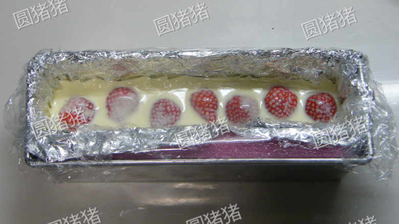 可可奶冻卷,倒入1/2的奶冻浆,放入<a style='color:red;display:inline-block;' href='/shicai/ 109017'>新鲜草莓</a>,移入冰箱冷藏1小时,再倒入剩下的1/2奶冻浆移入冰箱冷藏过夜。(如果剩下的奶冻浆已开始凝固,需隔水加热成液态再倒入)