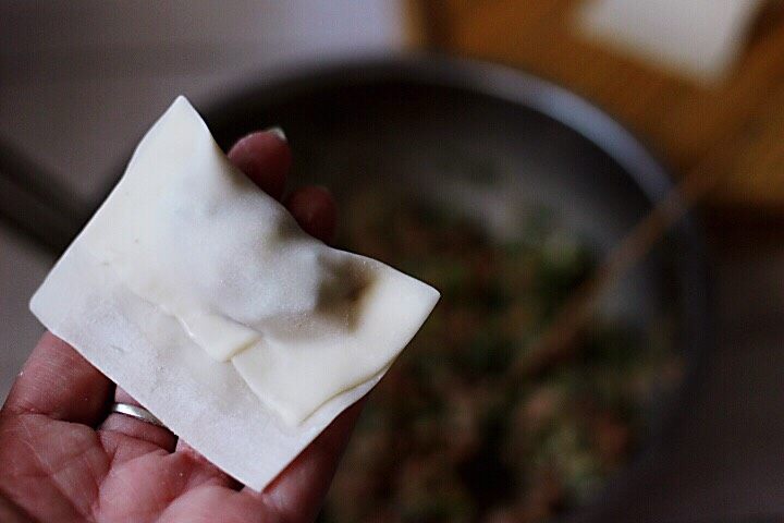 胶东半岛的三鲜馄饨,把上面的皮压在中间,用手把馄饨皮的周围捏紧后。