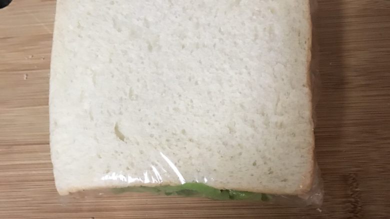 照烧鸡腿三明治,用保鲜膜将三明治包起来