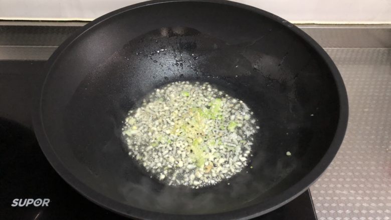 酸汤肥牛(微辣版),另起锅烧油,下葱姜蒜末炒香