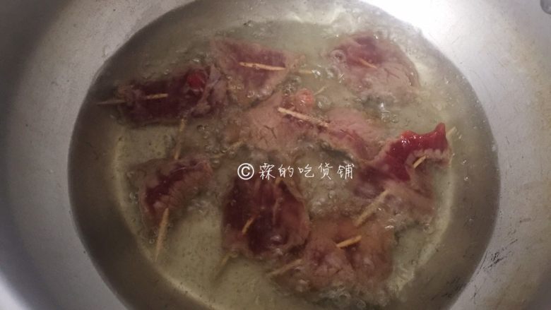 牙签牛肉,炸锅里放油，油锅烧至六成热，把牛肉串依次放入，一面变色了，赶快翻面，二面都变色了，牛肉片有点微微卷起就是好了