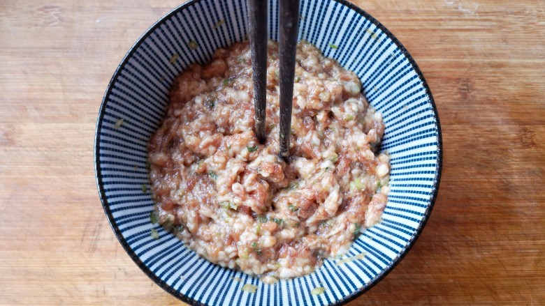 翡翠饺子——用一盘情意绵绵的饺子温暖整个冬天,将碗中的食材顺一个方向搅拌均匀,搅拌上劲儿(筷子在肉馅中能立住不倒)并用手将它们捏一下,帮助入味。捏好以后稍微尝一下肉馅的味道,根据自己的口味调整一下。然后,将肉馅放入冰箱中冷藏腌制一小时。