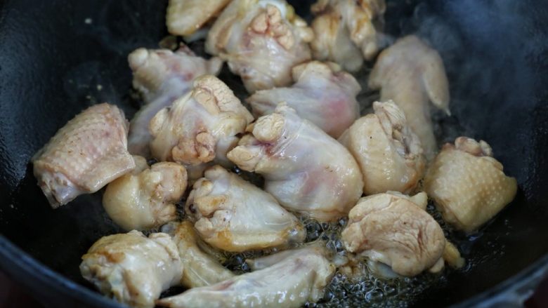 鸡翅腐竹烧土豆,锅中倒适量食用油烧热,放入鸡翅翻炒至发白变色