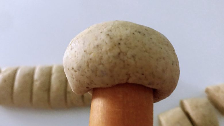 黑豆渣窝窝头,面团放左手掌心,用手不好弄就用擀面杖摁出小窝,慢慢摁一圈。