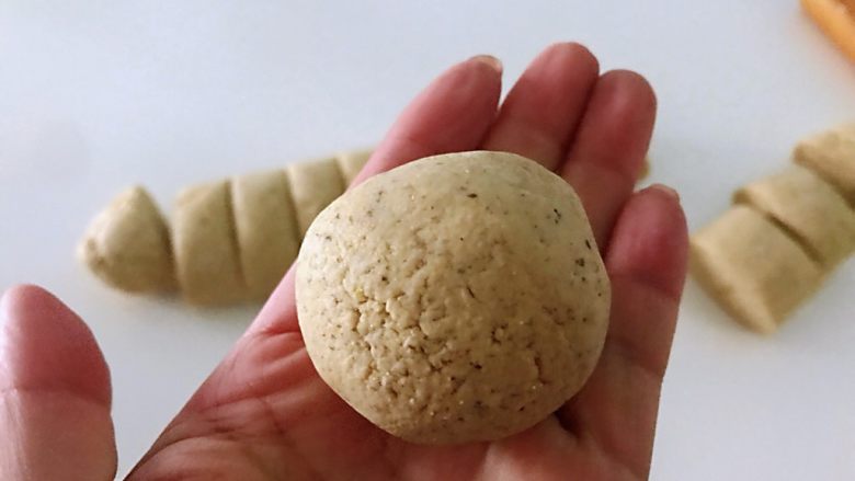 黑豆渣窝窝头,取一个面剂子,慢慢搓成圆形。