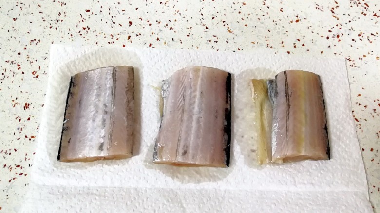 红烧带鱼,腌好的带鱼用厨房用纸吸去多余的水分,这样一会儿炸的时候就不容易溅油。