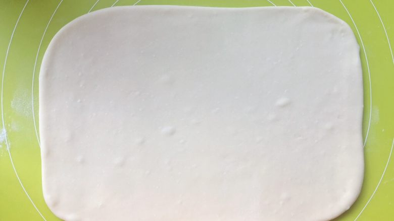 意式红烩牛柳酥,揉面垫上撒干粉,将揉好的面团擀成长方形,大小为小号保鲜膜的大小,之后入冰箱冷冻20分钟