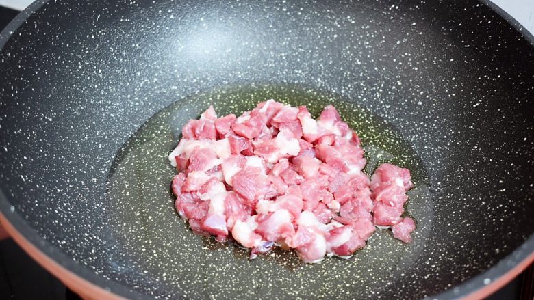 茄子打卤面,锅中倒入适量的油烧热,放入猪肉翻炒至变色变白