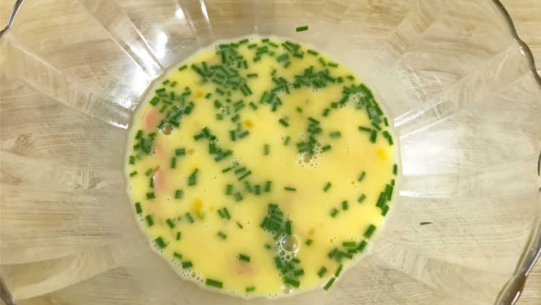泡面火腿肠烘蛋,鸡蛋打散,再放入火腿肠片,放入香葱,然后加入少许盐和<a style='color:red;display:inline-block;' href='/shicai/ 720'>胡椒粉</a>调味。