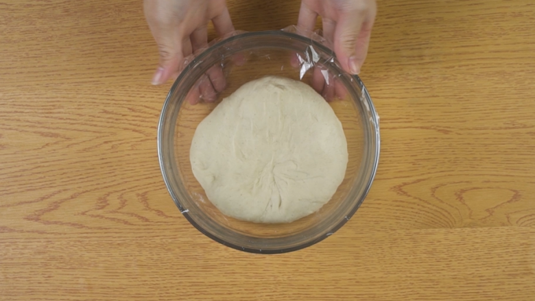 新疆烤馕,将面团不停揉至扩展阶段(即能用手拉出薄膜),盖上保鲜膜,置于温暖处发酵至原体积的两倍大