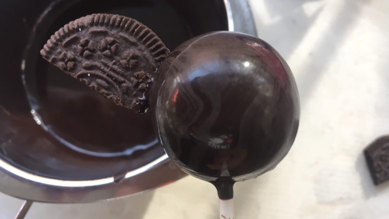 小魔鬼棒棒糖,将饼干的平角部分蘸上一点点热巧克力,点在棒棒糖一侧,做小蝙蝠的翅膀,等巧克力干透,再粘上另外一侧的饼干