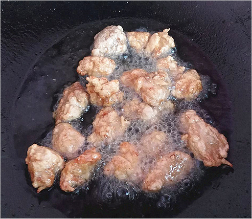 菠萝古老肉,锅里放油,油温6.7成热的时候放入肉块炸至金黄色捞出;