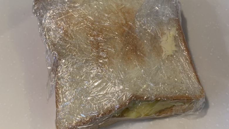厚蛋烧芝士脆皮肠三明治,用保鲜膜包好,对半切就可以吃了