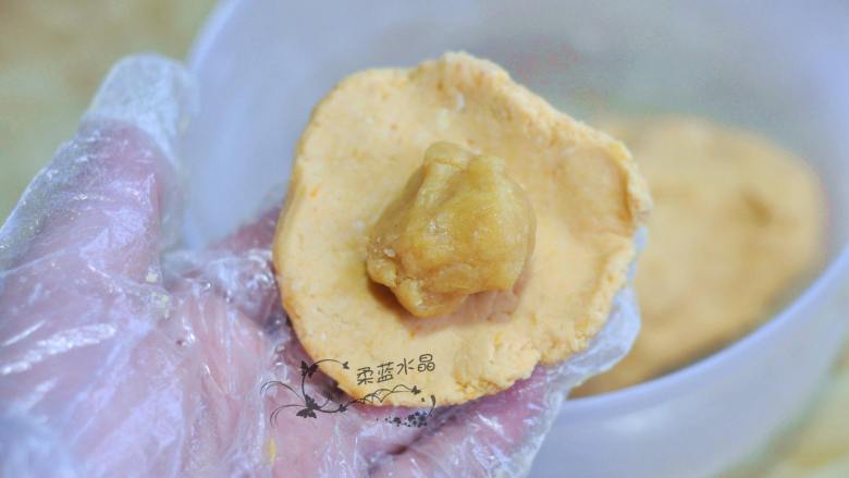 红薯蛋黄饼,取一块面团揉圆压扁,放入馅料包起来,稍微按扁。