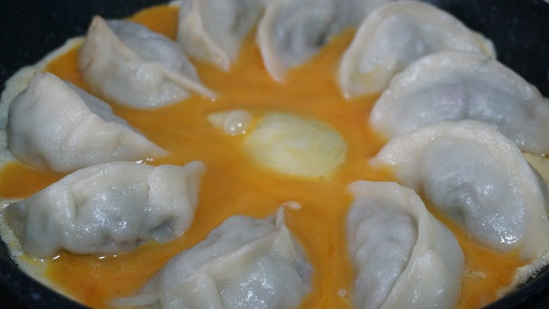 抱蛋牛肉茴香煎饺,顺锅边倒入鸡蛋液,转动下锅这样比较均匀,这里全程小火