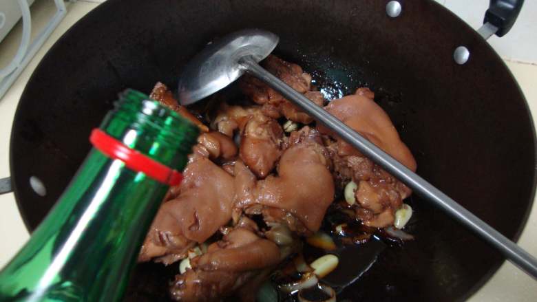 腊八蒜烧猪蹄,倒入调好的酱料炒香,放入猪蹄,加一瓶盖白酒炒匀