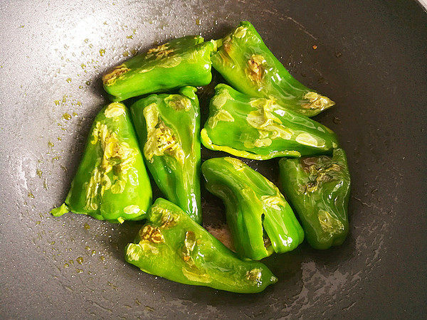 虎皮青椒,油煎至青椒出现虎皮翻面,继续油煎,不要翻动,直至青椒四周都出现虎皮。