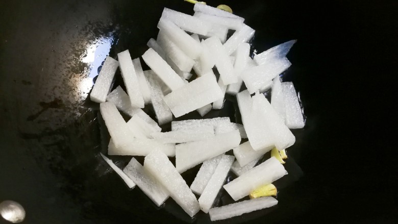 青蒜萝卜圆子汤,放入白萝卜条翻炒片刻