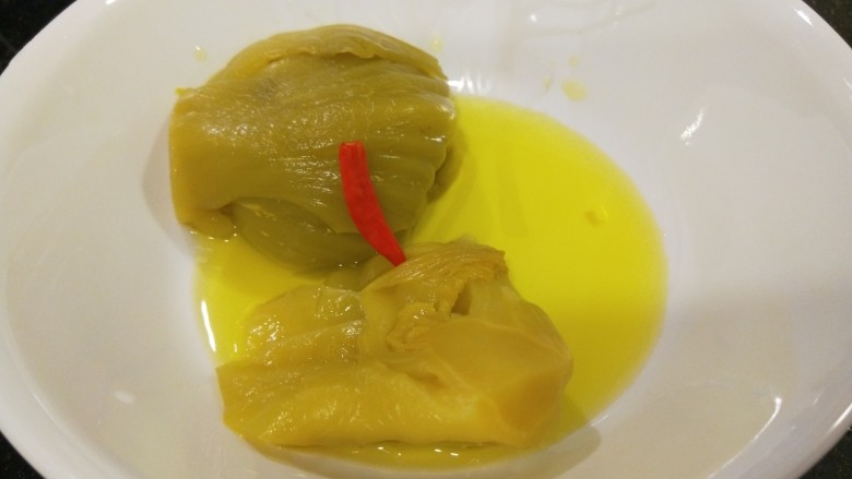 新文美食 酸菜红雕鱼,酸菜倒入碗中,汤一起倒入。