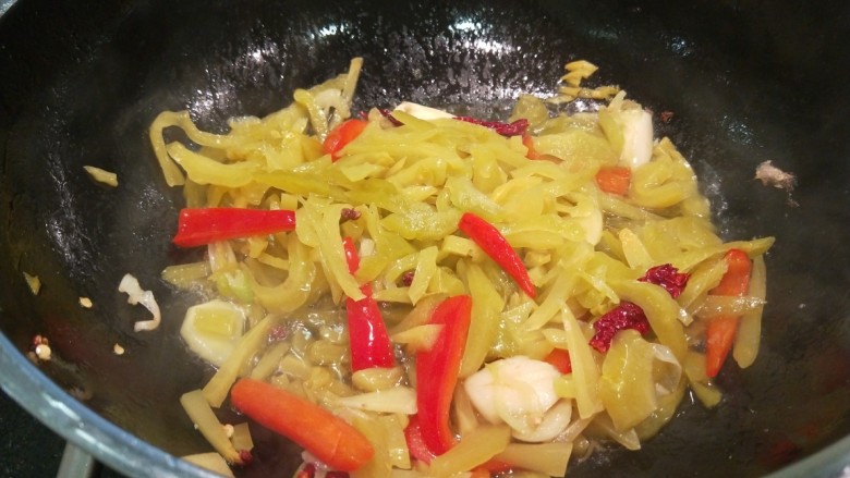 新文美食 酸菜红雕鱼,锅中倒入适量油烧热,放入葱姜蒜炒香,倒入酸菜丝炒出酸味。