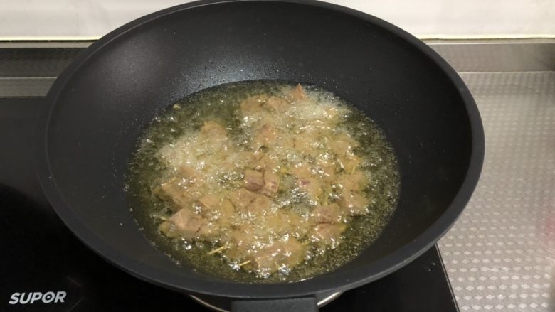 孜然牙签牛肉,将牛肉下锅,用筷子不停搅动,中小火