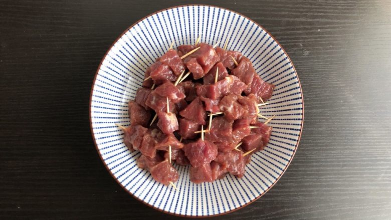 孜然牙签牛肉,用牙签将牛肉块串起,一根牙签串2块