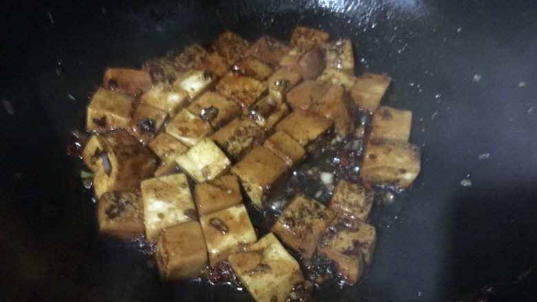 红烧豆腐(下饭菜),倒入所有调料继续以掂锅的方式炒匀,调料不一定全放,根据个人口味适量添加,最后倒入水淀粉勾芡出锅撒葱花点缀