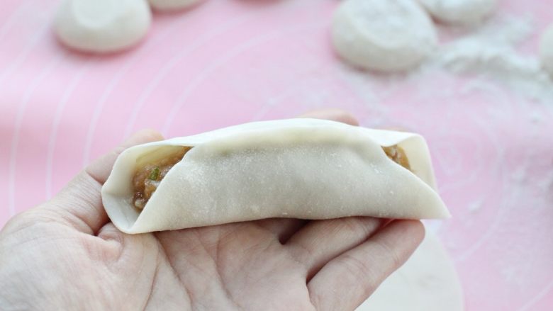 脆底猪肉洋葱锅贴,取一张饼皮放上适量馅料,然后将饼皮中间对折捏严即可