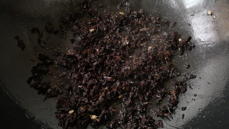 梅干菜肉酱意面,将泡发好的梅干菜攥去水后倒入锅中,中火翻炒出香味。