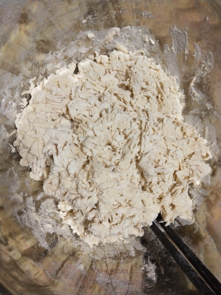 豆腐馅饼,<a style='color:red;display:inline-block;' href='/shicai/ 519'>面粉</a>中先加入开水,后加温水,搅拌成棉絮状。