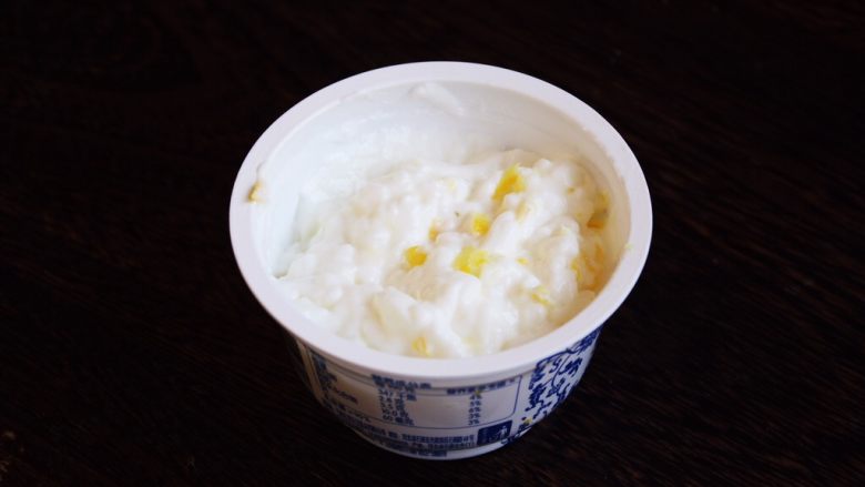 百变水果 柠香酸奶佐蜂蜜烤梨配法棍面包,将柠檬皮屑放在酸奶杯里,用小勺搅拌均匀。