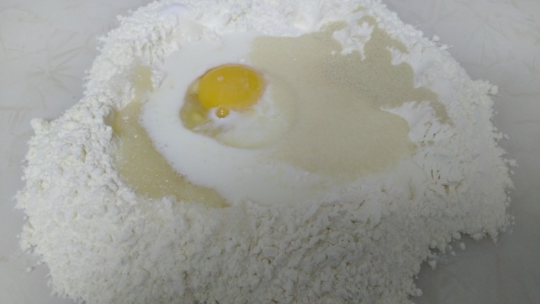 百香果奶味🐛豆沙面包,面粉倒在操作台上，挖坑，打入<a style='color:red;display:inline-block;' href='/shicai/ 9'>鸡蛋</a>，倒入牛奶、<a style='color:red;display:inline-block;' href='/shicai/ 6021'>百香果汁</a>，对角放入盐、<a style='color:red;display:inline-block;' href='/shicai/ 731'>酵母</a>、<a style='color:red;display:inline-block;' href='/shicai/ 3729'><a style='color:red;display:inline-block;' href='/shicai/ 3729'>白糖</a></a>。