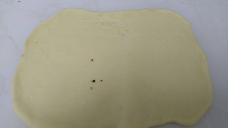 百香果奶味🐛豆沙面包,擀成长方形薄片。