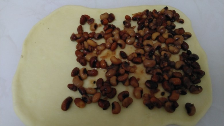 百香果奶味🐛豆沙面包,从一边开始抹上红豆沙，留一边不涂。讲一下豆沙的制作：花红豆洗净，放入砂锅中，加入清水1000克，白糖30克，大火煮开转小火煮80分钟。