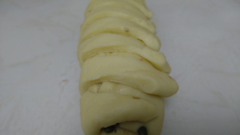 百香果奶味🐛豆沙面包,扯起包到卷起的那边，直到每条都包好，🐛的样子就有了，用绿豆当眼镜。