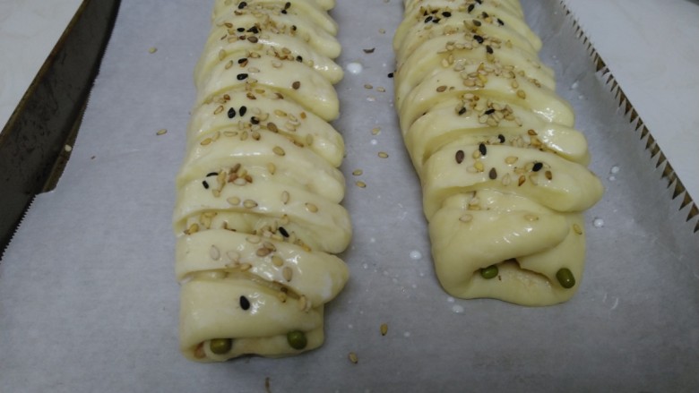 百香果奶味🐛豆沙面包,放入烤盘，均匀涂上纯奶，撒上熟<a style='color:red;display:inline-block;' href='/shicai/ 666'>芝麻</a>。