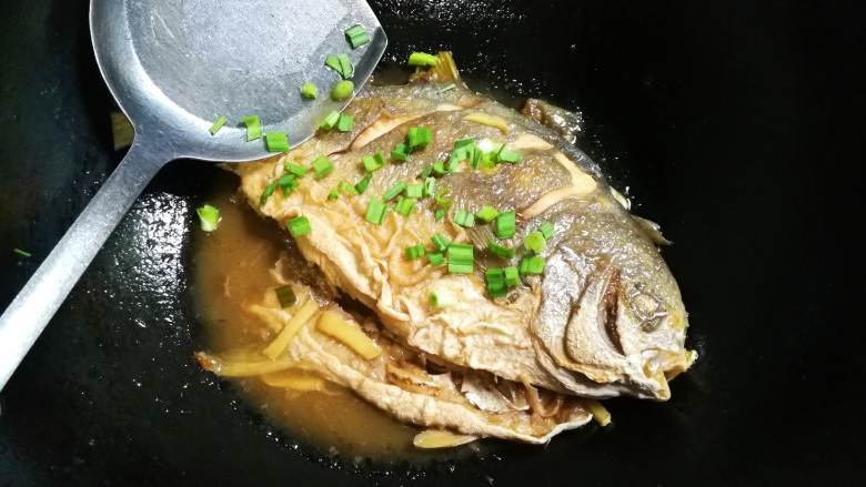 青蒜金昌鱼,中火烧至汤汁还剩三分之一,中途翻面,用勺子浇汤汁金昌鱼表面,撒入青蒜,青蒜经过热气一熏,味道特别好