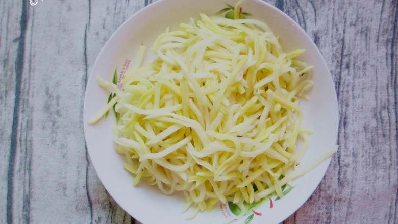 粉蒸土豆丝,这时候会腌制一些水处来,用纱布包住土豆丝,用力把水挤出来。